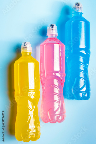 Plastic bottles with colored liquid. Colored bottles of sports nutrition, isotonics.