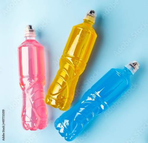 Plastic bottles with colored liquid. Colored bottles of sports nutrition, isotonics.