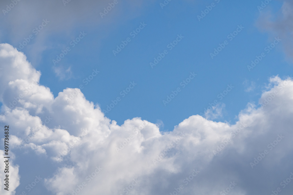 Blue sky with white clouds in sunny weather. Fluffy white cloud against a clear blue sky. Bright contrasting sky with clouds. Sky-cloud background Blue sky with white clouds in sunny weather. Fluffy white cloud against a clear blue sky. Bright contrasting sky with clouds. Sky-cloud background