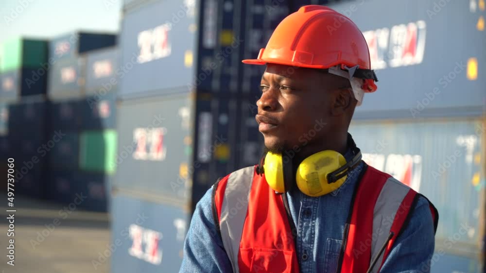 portrait of african american container worker confident and smiling standing at warehouse logistic in Cargo freight ship for import export in harbor. shipping in docks . happy employee arms crossed portrait of african american container worker confident and smiling standing at warehouse logistic in Cargo freight ship for import export in harbor. shipping in docks . happy employee arms crossed
