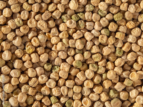 Food-grade natural textured background of yellow dried pea seeds. Pea background. Close-up of whole organic dry peas Top View