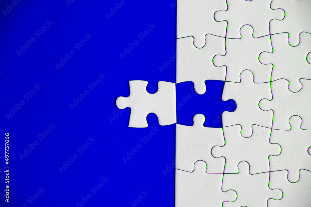 Fototapeta premium Top view of missing jigsaw puzzle on blue cover background. Copy space