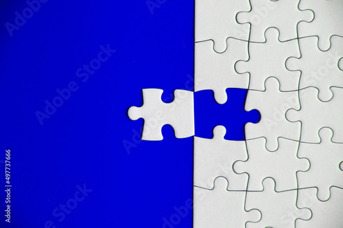 Top view of missing jigsaw puzzle on blue cover background. Copy space