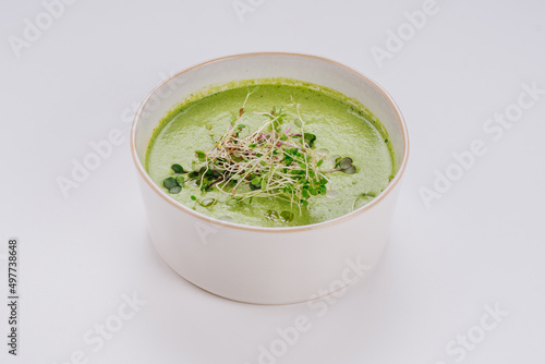 Dish of spinach cream soup and greens. Close up