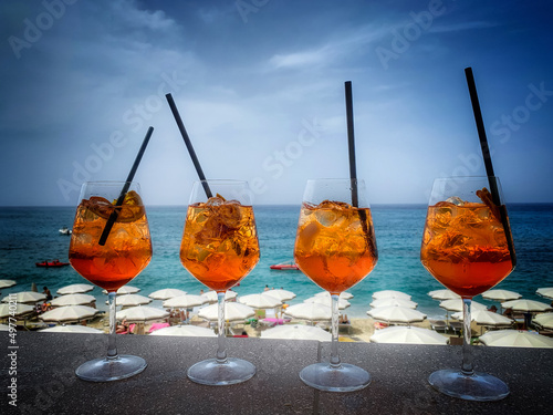 cztery kolorowe drinki na tle plaży i morza.