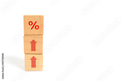 Concept of financial and mortgage interest rates. Wooden cube block increasing from above with icon percent symbol up.