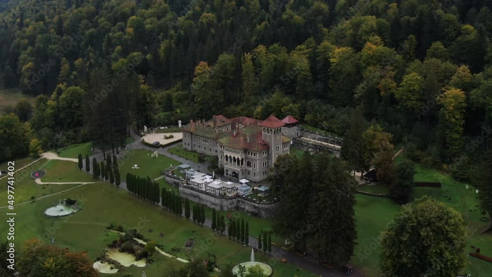 Aerial view of a big palace and its gardens between mountain trees on a clouded day Aerial view of a big palace and its gardens between mountain trees on a clouded day