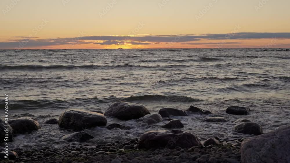 the sun sets below the horizon, setting in sea water. beautiful sunset on the sea. the sun setting in the clouds. waves run on the water the sun sets below the horizon, setting in sea water. beautiful sunset on the sea. the sun setting in the clouds. waves run on the water