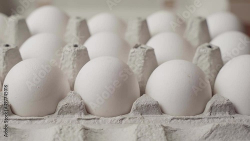 Dolly shot of whites eggs in cardboard box, side view
