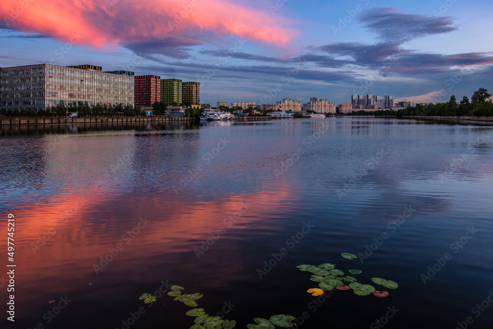 View of modern buildings near the water during sunset