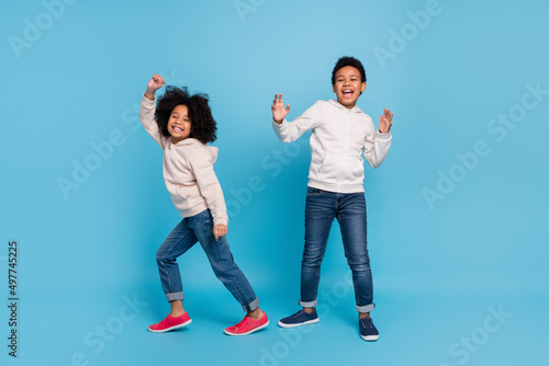 Full length body size view of attractive cheerful kids dancing moving having fun isolated over bright blue color background