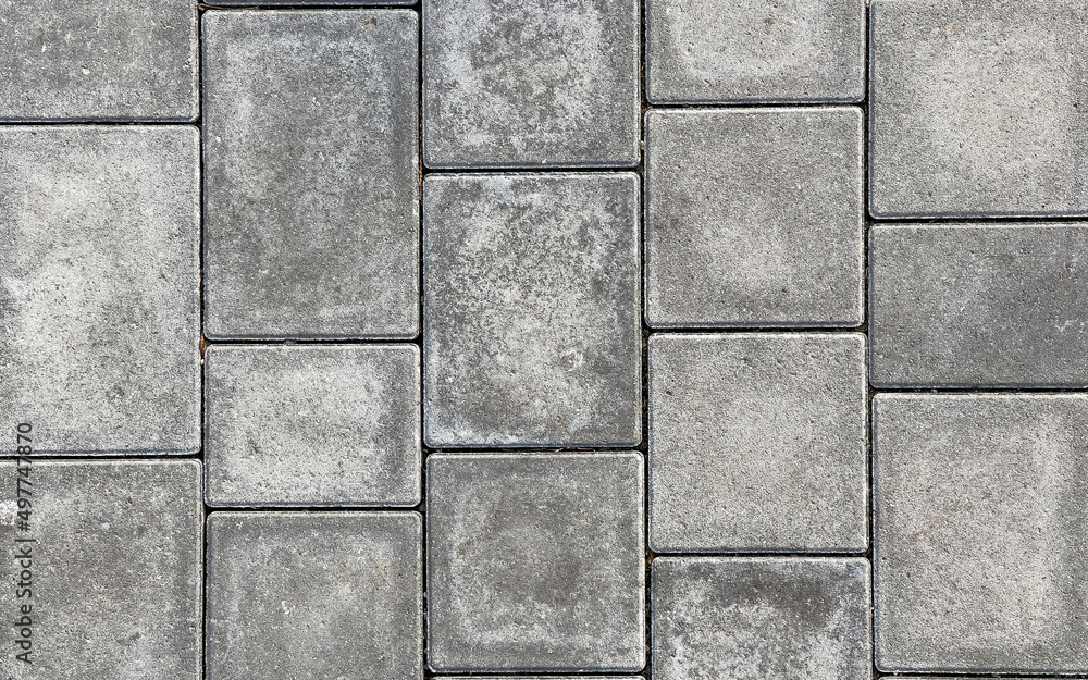 Naklejka premium Rough textured surface of large gray paving slabs, close up. Pavement tile pattern, top view