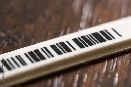 Tiny plastic security anti-theft barcode sticker with chip. photo