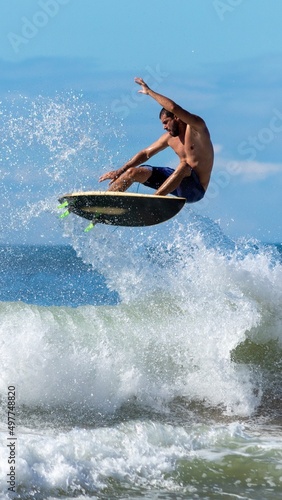SURFISTA FAZENDO UMA MANOBRA AERIA.