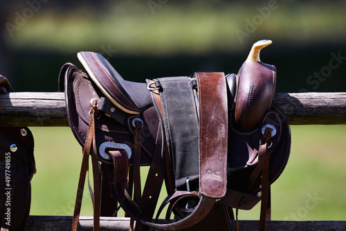 Ready to ride. Cropped shot of a saddle on a fence.