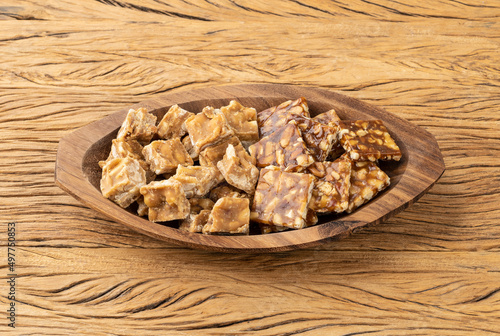 Pe de moleque, typical brazilian peanut candy over wooden table. June festival food photo