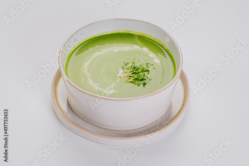 Dish of spinach cream soup and greens. Close up