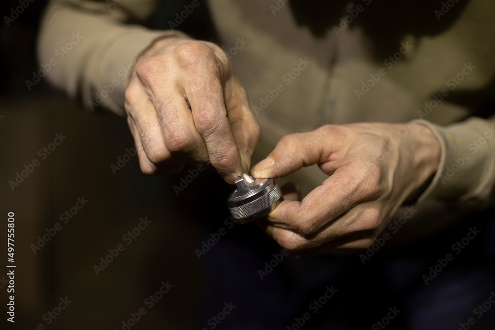 Fototapeta premium Valve from spray gun in hands. Repair parts of paint remote. Cleaning valve.