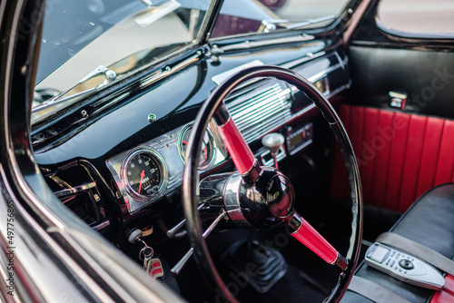 Classic car interior with steering wheel and chrome dash with leather seats