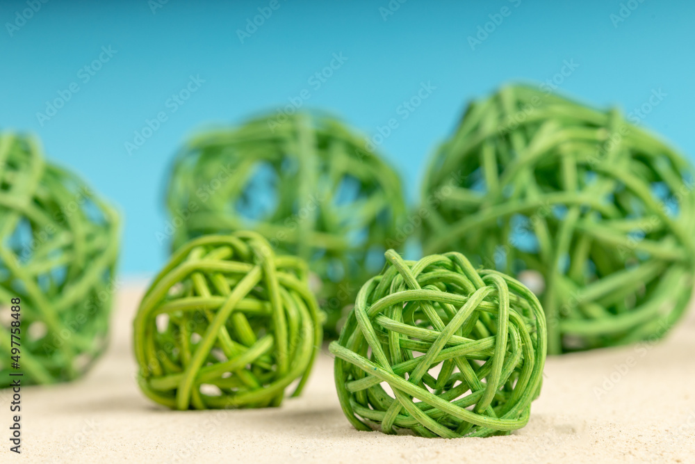 green decorative wicker balls on the sand green decorative wicker balls on the sand