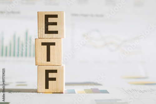 ETF word written on wood block on chart background .