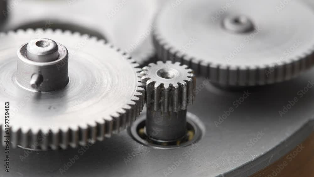 Gears rotating in a mechanical device. Machine metal gears rotating abstract. Cog wheels machinery, close up, macro Gears rotating in a mechanical device. Machine metal gears rotating abstract. Cog wheels machinery, close up, macro