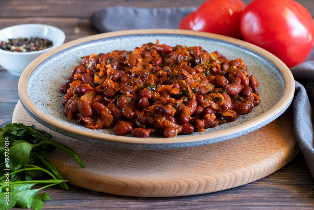 Lobio made of red beans on wooden cutting board with gray textiles, close-up Lobio made of red beans on wooden cutting board with gray textiles, close-up