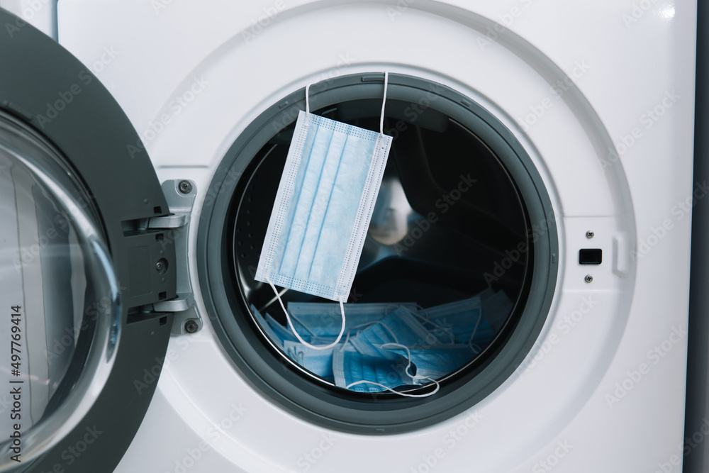 Medical masks in washing machine. Washing machine loading Medical masks in washing machine. Washing machine loading