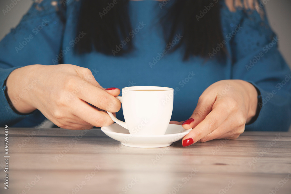 woman hand cup of coffee on the desk woman hand cup of coffee on the desk