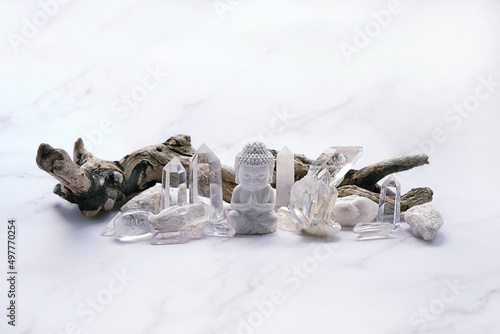 Clear quartz minerals and Buddha statue on light marble background. gemstones crystals for healing esoteric ritual, spiritual Magic practice, relaxation, meditation. life balance concept