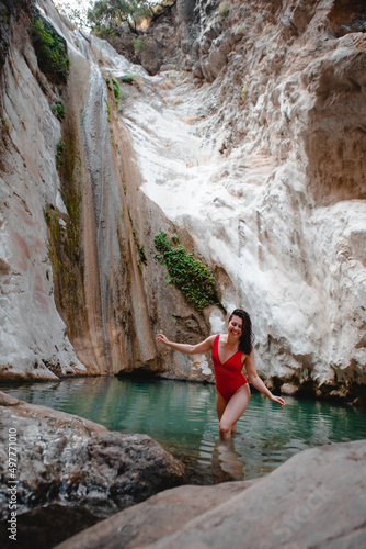 woman in red swimsuit Dimosari waterfall at Lefkada island Greece