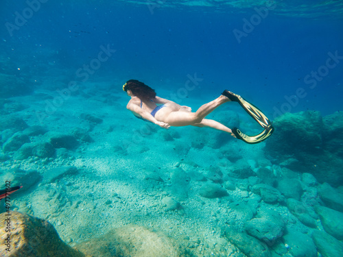 beautiful woman swimming underwater with snorkeling mask and flippers
