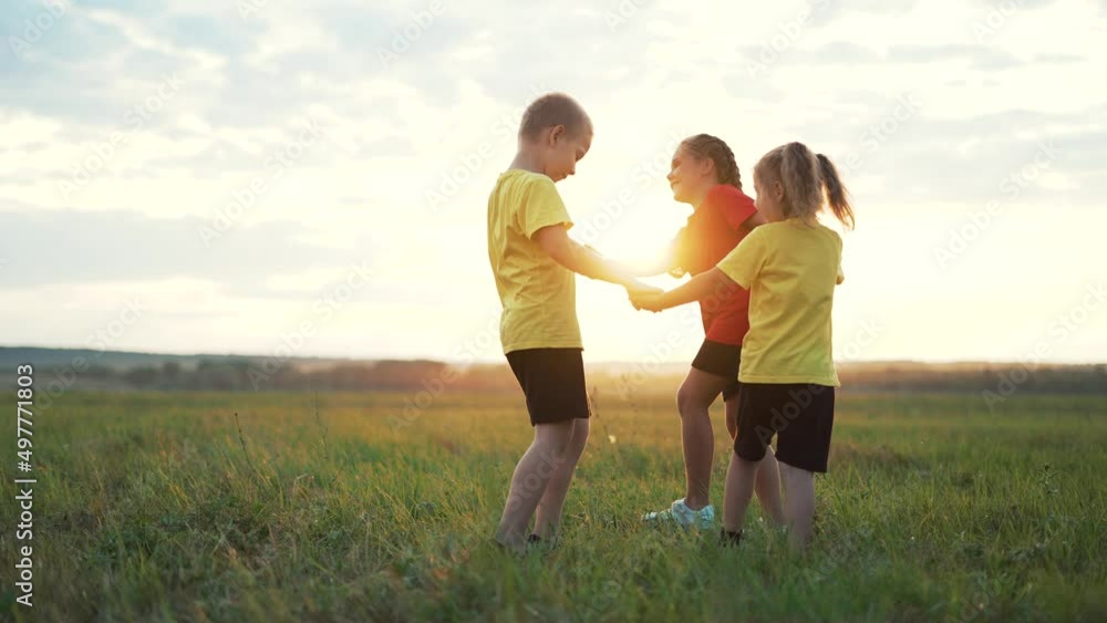 Happy family concept.Group of children holding hand in round dance.Brother and sister are play in park on grass.Active lifestyle concept. Family on green grass. Happy children play round dance in park Happy family concept.Group of children holding hand in round dance.Brother and sister are play in park on grass.Active lifestyle concept. Family on green grass. Happy children play round dance in park