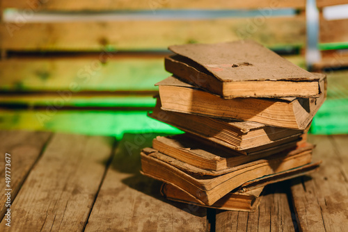 Obraz na płótnie Stack of very dusty, antique books on wooden board with blurred background w salonie