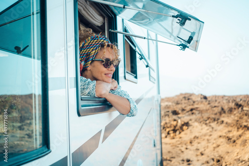 Foto Happy young atractive woman admire and enjoy the view from modern camper van window