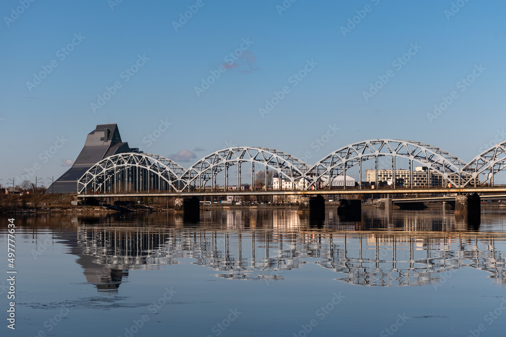 Fototapeta premium The Railway Bridge over the River Daugava in Riga, Latvia on a bright day in sprin