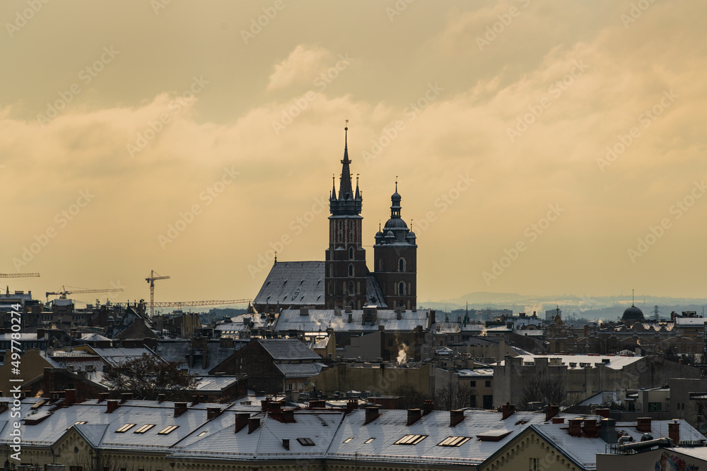 Aerial panorama of Old Krakow at dawn with St. Mary's Basilica on the medieval main market square of the city, snow on the roofs of Krakow houses in cloudy weather, Poland