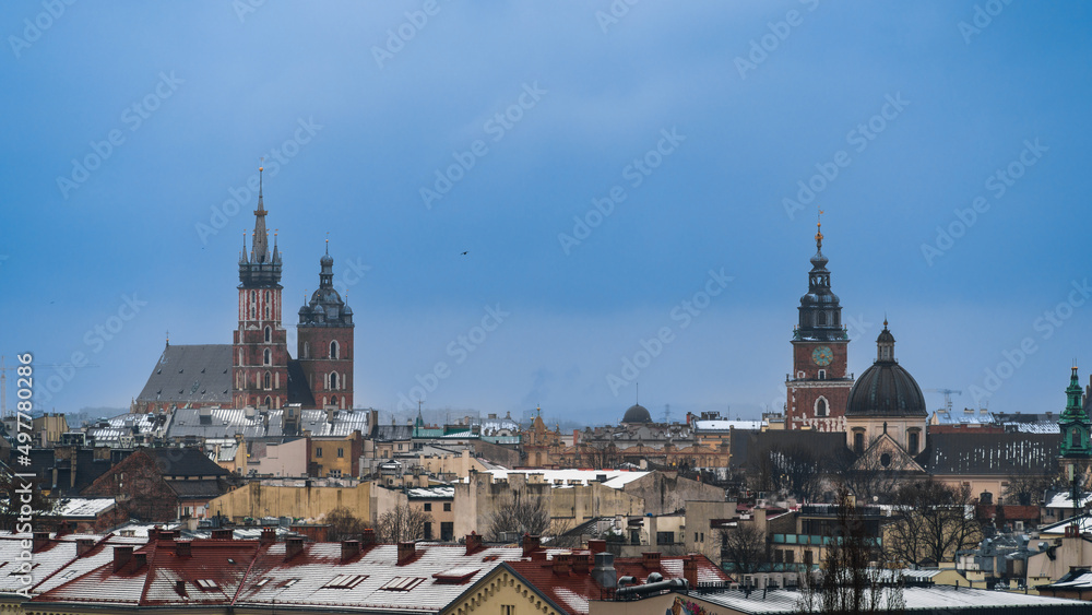 Aerial panorama of Old Krakow with St. Mary's Basilica and town hall tower on the medieval main market square of the city, snow on the roofs of Krakow houses in cloudy weather, Poland