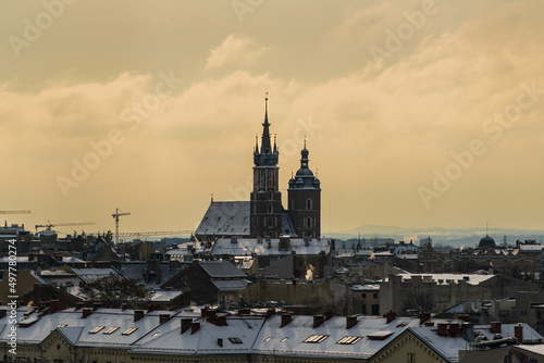 Aerial panorama of Old Krakow at dawn with St. Mary's Basilica on the medieval main market square of the city, snow on the roofs of Krakow houses in cloudy weather, Poland © Александр Бочкала