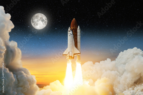 Spaceship lift off. Space shuttle with smoke and blast takes off into space on a background of a sunset with a full moon and stars in the sky. Elements of this image furnished by NASA.