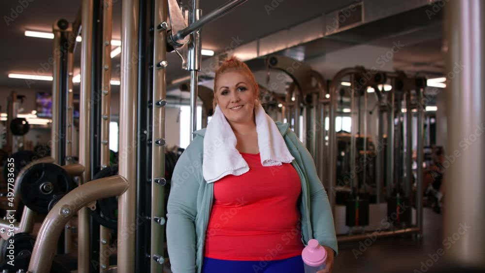 Happy fat woman after exercise indoors in gym, looking at camera. Happy fat woman after exercise indoors in gym, looking at camera.