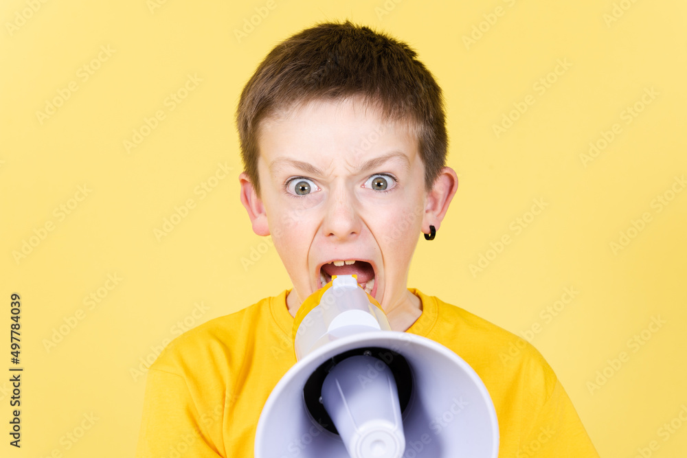 Angry boy shouting on megaphone and looking straight to camera Angry boy shouting on megaphone and looking straight to camera