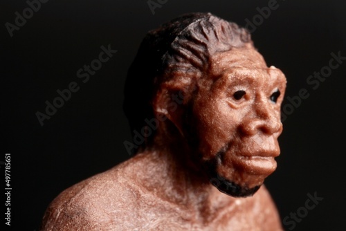 close up portrait of a primitive man doll on a black background