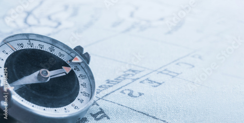 Magnetic old compass on world vintage  map.Travel, geography, navigation, tourism and exploration concept background.Macro shot, shallow focus.