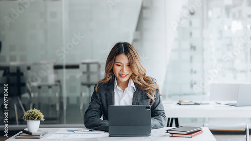 Canvastavla A businesswoman is checking company financial documents and using a tablet to talk to the chief financial officer through a messaging program