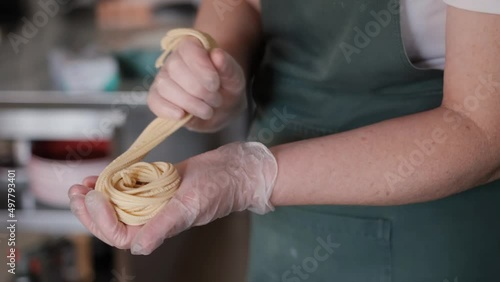 Healthy italian food. Making pasta pasta machine. Slow motion. Restaurant cooking. Making homemade noodles with rolling machine. fresh spaghetti on chef hand Full hd