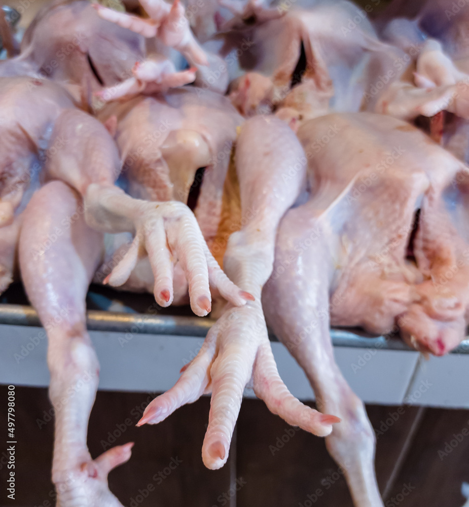 Whole raw chickens, plucked, washed and stacked in the butcher shop Whole raw chickens, plucked, washed and stacked in the butcher shop