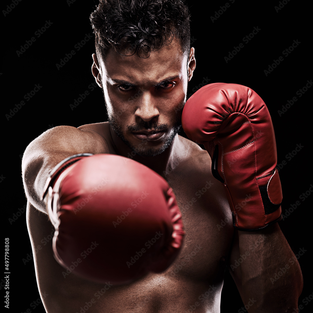 Do or do not - there is no try. Portrait of a young man wearing boxing gloves against a black background.