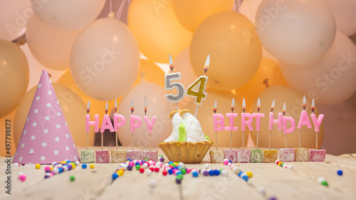 Beautiful background happy birthday number 54 with burning candles, birthday candles pink letters for fifty four years. Festive background with balloons photo