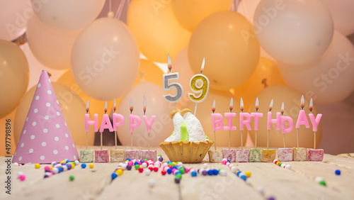 Beautiful background happy birthday number 59 with burning candles, birthday candles pink letters for fifty nine years. Festive background with balloons photo